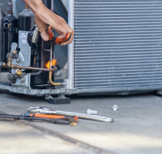 guys hands fixing outdoor ac unit